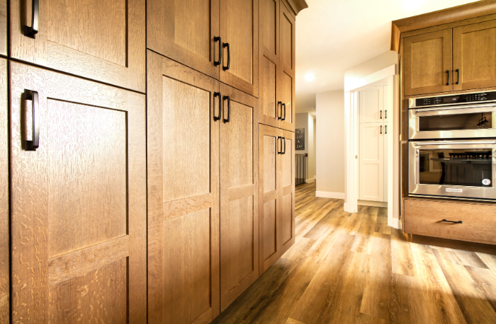 brown cabinets custom cabinets and hardware in kitchen with wood flooring and double ovens